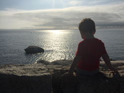 Image of a child looking out at the water.